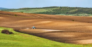 Le tracteur laboure le gisement de ressort avant un ensemencement Photos stock Le tracteur laboure le gisement de ressort avant un ensemencement Photos stock