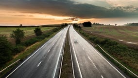 Le trafic sur l'autoroute rurale au coucher du soleil Le trafic sur l'autoroute rurale au coucher du soleil