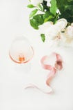 Le vin de Rose en verre, ruban décoratif rose, pivoine fleurit Images libres de droits Le vin de Rose en verre, ruban décoratif rose, pivoine fleurit Images libres de droits