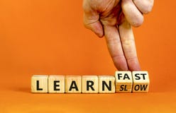 Learn slow or fast symbol. Businessman turns wooden cubes and changes words `learn slow` to `learn fast`. Beautiful orange