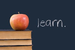 Learn written on blackboard with apple and books Royalty Free Stock Image Learn written on blackboard with apple and books Royalty Free Stock Image