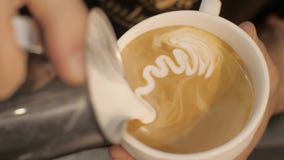 Leche de colada de Barista en café y la fabricación de espuma del capuchino con cierre del corazón para arriba metrajes Leche de colada de Barista en café y la fabricación de espuma del capuchino con cierre del corazón para arriba metrajes