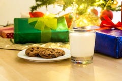 Leche y galletas para Papá Noel debajo del árbol de navidad foto de archivo libre de regalías Leche y galletas para Papá Noel debajo del árbol de navidad foto de archivo libre de regalías