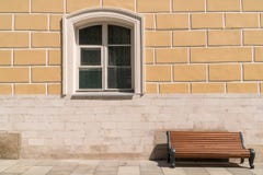 Leere Bank gegen die Wand mit einem Fenster lizenzfreie stockbilder Leere Bank gegen die Wand mit einem Fenster lizenzfreie stockbilder