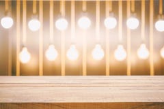 Leere hölzerne Tischplatte und Unschärfe des gelben Birnenlichtes und des bokeh herein lizenzfreie stockbilder Leere hölzerne Tischplatte und Unschärfe des gelben Birnenlichtes und des bokeh herein lizenzfreie stockbilder