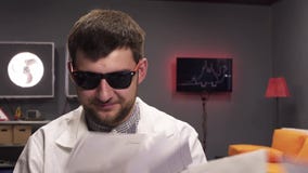 Leere Umschläge fallen auf netter junger Mannestragende Sonnenbrille und weißen Laborkittel stock video Leere Umschläge fallen auf netter junger Mannestragende Sonnenbrille und weißen Laborkittel stock video