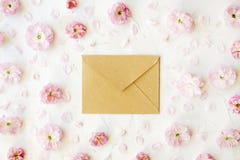 Leerer geschlossener Kraftpapierumschlag für Mutter ` s Tag mit Kopienraum für Text unter rosa blühenden Blüten auf weißem Hinter stockfoto Leerer geschlossener Kraftpapierumschlag für Mutter ` s Tag mit Kopienraum für Text unter rosa blühenden Blüten auf weißem Hinter stockfoto