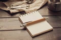 Leeres Leerraumnotizbuch mit Stift- und Gebäckbäckereiwerkzeugen auf hölzernem Hintergrund lizenzfreies stockfoto Leeres Leerraumnotizbuch mit Stift- und Gebäckbäckereiwerkzeugen auf hölzernem Hintergrund lizenzfreies stockfoto
