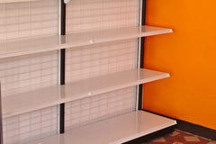 Lege planken in de supermarkt met oranje muren stock afbeeldingen Lege planken in de supermarkt met oranje muren stock afbeeldingen