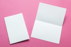 Lege vierkante die twee-blad brochures op roze achtergrond worden ge?soleerd Model stock afbeeldingen Lege vierkante die twee-blad brochures op roze achtergrond worden ge?soleerd Model stock afbeeldingen