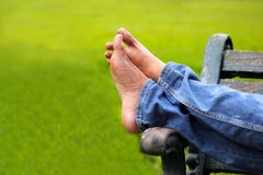 Legs Of Relaxing Adult Person On A Park Bench Stock Photo