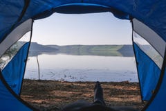 Legs of the traveler in a tent outdoors. Inside my tent, lake and camping, summer day royalty free stock image Legs of the traveler in a tent outdoors. Inside my tent, lake and camping, summer day royalty free stock image