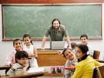Lehrer im Klassenzimmer mit seinem kleinen Kursteilnehmer stockfotografie Lehrer im Klassenzimmer mit seinem kleinen Kursteilnehmer stockfotografie