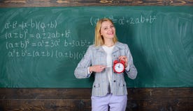 Lehreringriffwecker Sie interessiert sich für Disziplin Zeit zu studieren Willkommenes LehrerSchuljahr schauen stockfotos Lehreringriffwecker Sie interessiert sich für Disziplin Zeit zu studieren Willkommenes LehrerSchuljahr schauen stockfotos