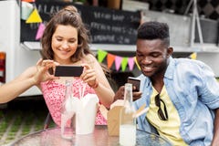 Mixed race couple photographing wok at food truck Royalty Free Stock Images Mixed race couple photographing wok at food truck Royalty Free Stock Images