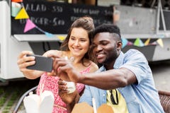 Mixed race couple taking selfie at food truck Royalty Free Stock Photography Mixed race couple taking selfie at food truck Royalty Free Stock Photography