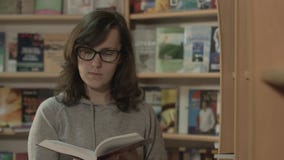 Leitura bonita da menina em uma biblioteca filme Leitura bonita da menina em uma biblioteca filme