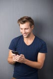 Leitura entusiasmado do homem sms em seu móbil fotografia de stock royalty free Leitura entusiasmado do homem sms em seu móbil fotografia de stock royalty free