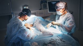 Lekarka i asystent w sala operacyjnej dla chirurgicznie kliniki Zdjęcia Stock Lekarka i asystent w sala operacyjnej dla chirurgicznie kliniki Zdjęcia Stock