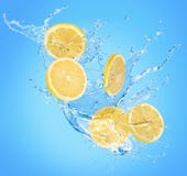 Lemon slices in water splash on a blue background stock photo Lemon slices in water splash on a blue background stock photo
