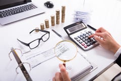 Lente d'ingrandimento di Checking Invoice With della donna di affari immagini stock libere da diritti Lente d'ingrandimento di Checking Invoice With della donna di affari immagini stock libere da diritti