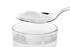 Lepel met zuiveringszout meer dan glas water stock foto's Lepel met zuiveringszout meer dan glas water stock foto's