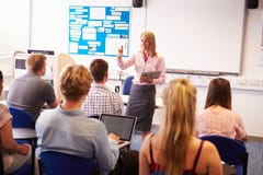 Leraar With College Students die Les in Klaslokaal geven royalty-vrije stock afbeelding Leraar With College Students die Les in Klaslokaal geven royalty-vrije stock afbeelding