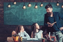 Leraar die met jonge schoolmeisjes bij bureau in klasse werken stock fotografie Leraar die met jonge schoolmeisjes bij bureau in klasse werken stock fotografie