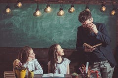 Leraar en schoolmeisjes op klaslokaalachtergrond Huis het scholen en terug naar schoolconcept Jonge geitjes en privé-leraar met h royalty-vrije stock afbeeldingen Leraar en schoolmeisjes op klaslokaalachtergrond Huis het scholen en terug naar schoolconcept Jonge geitjes en privé-leraar met h royalty-vrije stock afbeeldingen