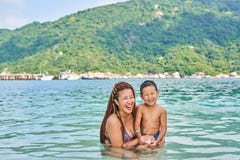 Les Asiatiques de maman et de fils se baignent en mer images libres de droits Les Asiatiques de maman et de fils se baignent en mer images libres de droits