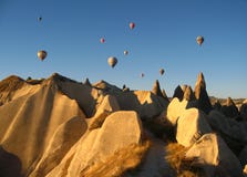 Les ballons royaux volant dans le lever de soleil s'allument dans Cappadocia, Turquie au-dessus du formation féerique Goreme voi images stock Les ballons royaux volant dans le lever de soleil s'allument dans Cappadocia, Turquie au-dessus du formation féerique Goreme voi images stock