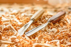 Les burins se sont étendus dans les copeaux en bois sur le bureau image stock Les burins se sont étendus dans les copeaux en bois sur le bureau image stock