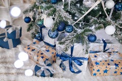 Les cadeaux de Noël enveloppés en papier argenté et bleu, fond avec Noël allume le bokeh de brouiller sous l'arbre de Noël photo libre de droits Les cadeaux de Noël enveloppés en papier argenté et bleu, fond avec Noël allume le bokeh de brouiller sous l'arbre de Noël photo libre de droits