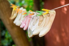 Les chaussures de ballet du ` s d'enfants sèchent sur une corde photographie stock libre de droits Les chaussures de ballet du ` s d'enfants sèchent sur une corde photographie stock libre de droits