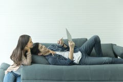 Les couples asiatiques semblent bons sur le sofa Regardez quelque chose par le Th photographie stock libre de droits Les couples asiatiques semblent bons sur le sofa Regardez quelque chose par le Th photographie stock libre de droits