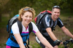 Les couples de sourire appréciant une bicyclette montent dehors image stock Les couples de sourire appréciant une bicyclette montent dehors image stock