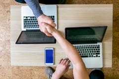 Les deux jeunes travaillant sur des ordinateurs portables dans le bureau Reposez-vous à la table vis-à-vis de l'un l'autre, poign photos libres de droits Les deux jeunes travaillant sur des ordinateurs portables dans le bureau Reposez-vous à la table vis-à-vis de l'un l'autre, poign photos libres de droits