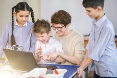 Les enfants heureux apprennent la programmation utilisant des ordinateurs portables sur les classes hors programme images stock Les enfants heureux apprennent la programmation utilisant des ordinateurs portables sur les classes hors programme images stock