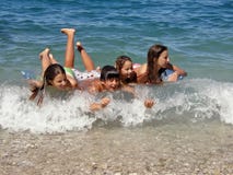 Les enfants heureux apprécient sur des ondes Image libre de droits Les enfants heureux apprécient sur des ondes Image libre de droits