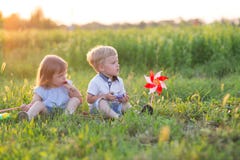 Les enfants s'asseyent sur l'herbe images stock Les enfants s'asseyent sur l'herbe images stock