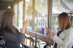 Les femmes asiatiques prennent des photos à un ami images libres de droits Les femmes asiatiques prennent des photos à un ami images libres de droits