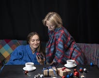 Les femmes dans des vêtements à la maison boivent du thé Fond noir images stock Les femmes dans des vêtements à la maison boivent du thé Fond noir images stock