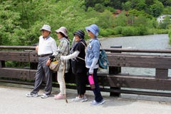 Les femmes japonaises pluses âgé d'homme jettent un pont sur des Alpes de montagnes de rivière, Kamikochi, Japon Images libres de droits Les femmes japonaises pluses âgé d'homme jettent un pont sur des Alpes de montagnes de rivière, Kamikochi, Japon Images libres de droits