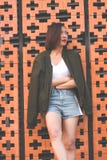 Les femmes se tiennent contre le mur de briques images stock Les femmes se tiennent contre le mur de briques images stock