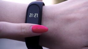 Les filles ont utilisé un bracelet de forme physique La fille vérifie l'impulsion sur le podomètre de bracelet de forme physique images stock Les filles ont utilisé un bracelet de forme physique La fille vérifie l'impulsion sur le podomètre de bracelet de forme physique images stock
