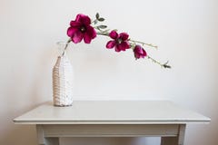 Les fleurs violettes dans le vase blanc sur le vintage en bois de table conçoivent images stock Les fleurs violettes dans le vase blanc sur le vintage en bois de table conçoivent images stock