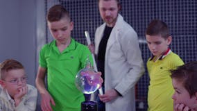 Les garçons fait l'expérience avec la bobine de Tesla et la sphère en verre Les garçons fait l'expérience avec la bobine de Tesla et la sphère en verre