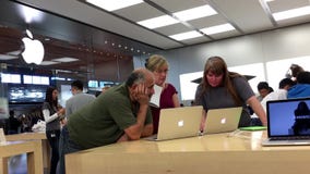 Les gens achetant nouveau Macbook à l'intérieur de magasin d'Apple Les gens achetant nouveau Macbook à l'intérieur de magasin d'Apple