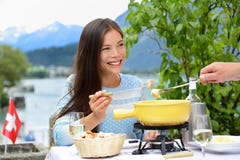 Les gens mangeant la fondue de fromage suisse dînant photographie stock libre de droits Les gens mangeant la fondue de fromage suisse dînant photographie stock libre de droits