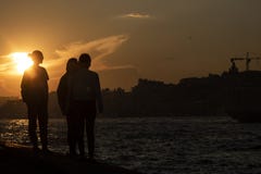 Les gens observant le coucher du soleil et la mer photographie stock libre de droits Les gens observant le coucher du soleil et la mer photographie stock libre de droits
